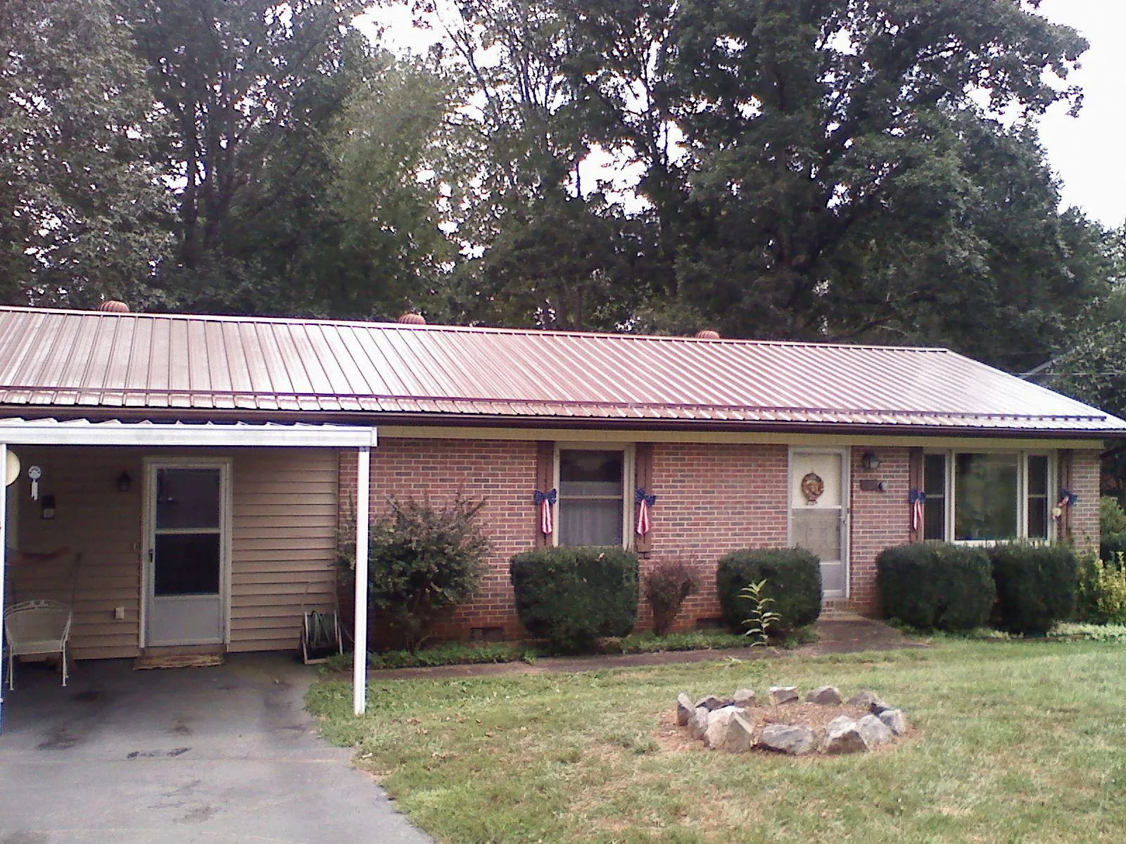 Bronze metal roof and carport on a brick ranch home — Roof Repair work by our crew in Mount Dora
